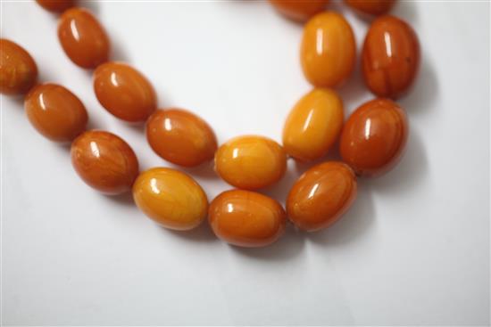 A single strand graduated oval amber bead necklace, 67cm.